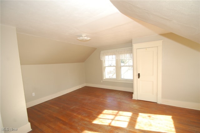 additional living space with wood-type flooring and lofted ceiling