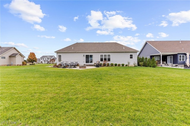 back of house with a lawn and a patio