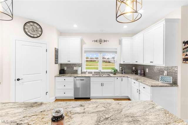 kitchen with dishwasher, white cabinets, and hanging light fixtures