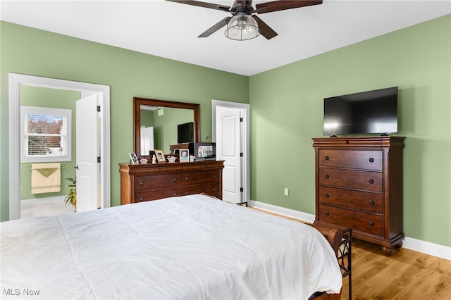 bedroom with connected bathroom, ceiling fan, and light hardwood / wood-style flooring