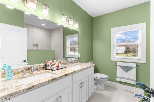 bathroom featuring tile patterned flooring, a shower, vanity, and toilet