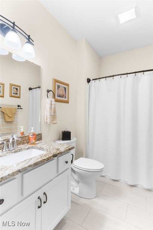 bathroom with vanity, toilet, and tile patterned flooring