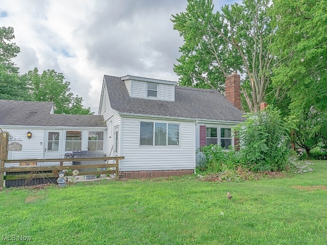 cape cod-style house featuring a wooden deck and a front yard