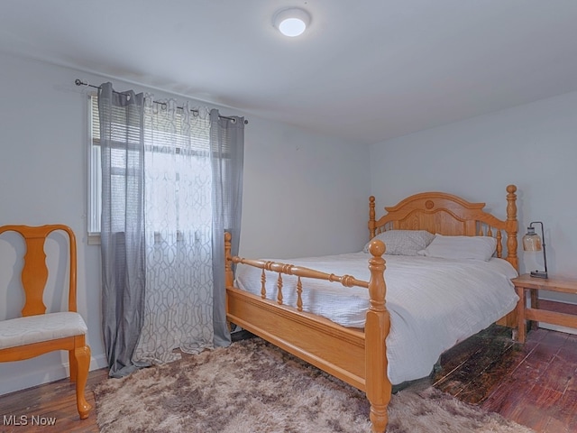 bedroom with dark hardwood / wood-style flooring