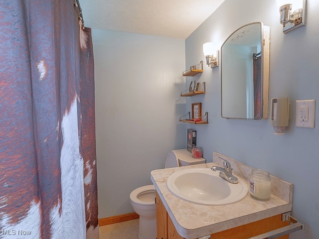 bathroom with vanity, a textured ceiling, and toilet