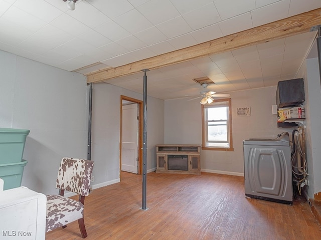 living room featuring hardwood / wood-style floors, beam ceiling, ceiling fan, and washing machine and dryer