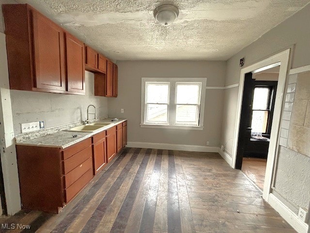 kitchen featuring sink, dark wood-type flooring, and a textured ceiling