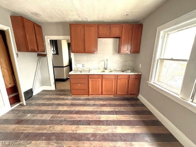 kitchen featuring a textured ceiling, sink, dark hardwood / wood-style floors, and tasteful backsplash