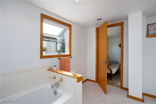 bathroom with a bathing tub, tile patterned floors, and a textured ceiling