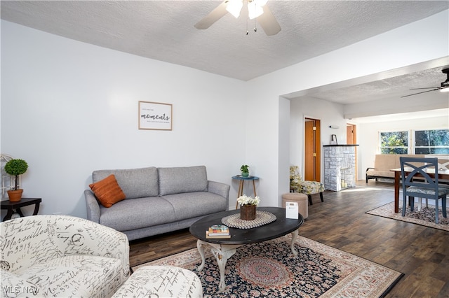 living room with hardwood / wood-style floors, a textured ceiling, and ceiling fan