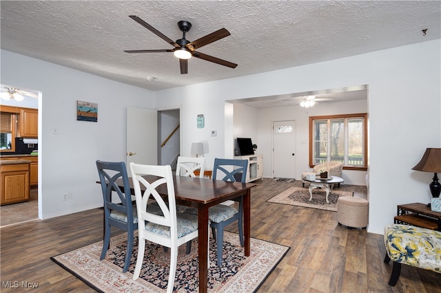 dining room featuring ceiling fan, dark wood-type flooring, and a textured ceiling