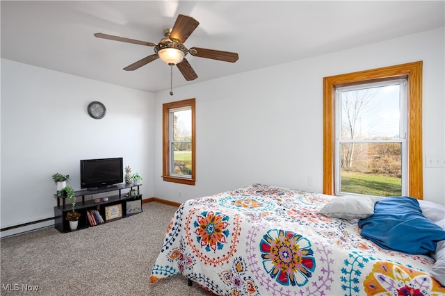 carpeted bedroom featuring baseboard heating, multiple windows, and ceiling fan