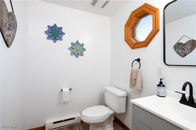 bathroom featuring baseboard heating, toilet, vanity, and hardwood / wood-style flooring