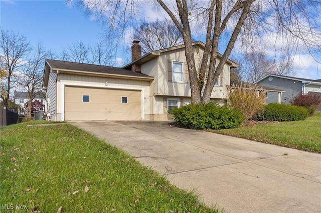 split level home featuring a front yard, central AC, and a garage