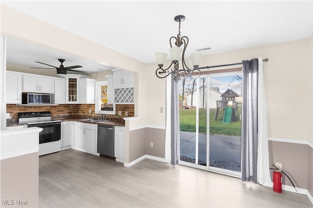 kitchen with appliances with stainless steel finishes, light wood-type flooring, white cabinetry, and hanging light fixtures