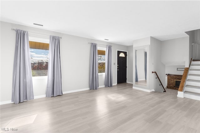 unfurnished living room with a fireplace and light hardwood / wood-style flooring