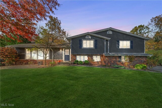 split level home featuring a lawn