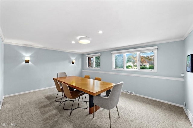 carpeted dining space with ornamental molding