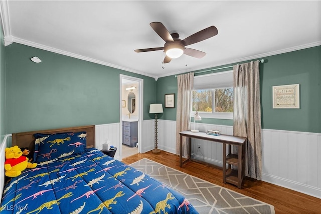 bedroom featuring wood-type flooring, ornamental molding, ensuite bathroom, and ceiling fan