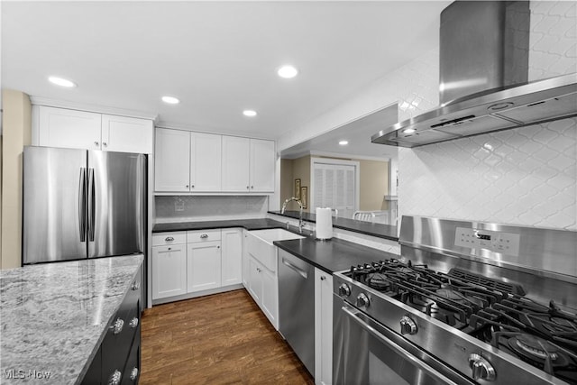 kitchen featuring stainless steel appliances, wall chimney range hood, white cabinets, and light stone counters