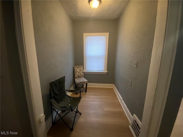 unfurnished room with hardwood / wood-style floors and a textured ceiling