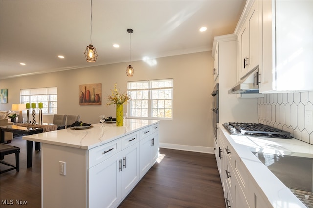 kitchen featuring stainless steel gas stovetop, white cabinetry, a kitchen island, and pendant lighting