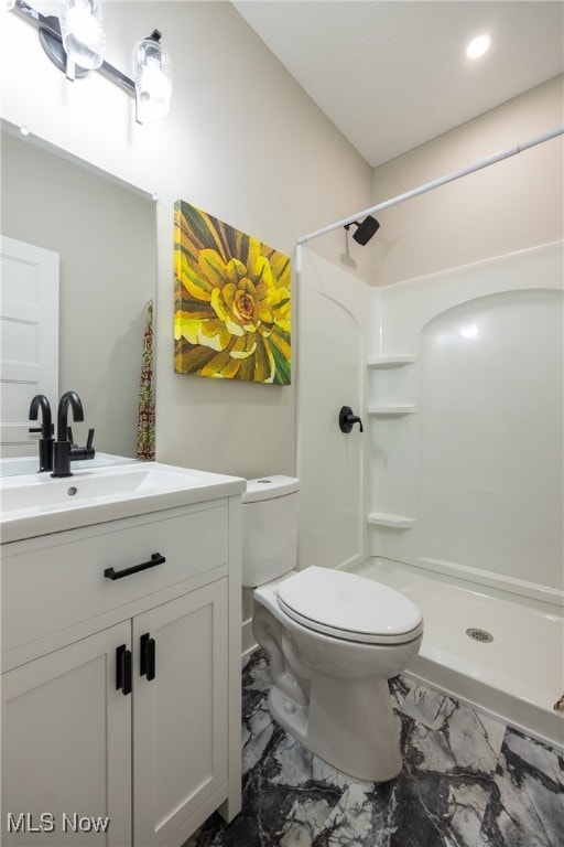 bathroom featuring a shower, vanity, and toilet