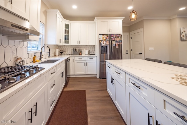 kitchen with sink, crown molding, pendant lighting, white cabinets, and appliances with stainless steel finishes