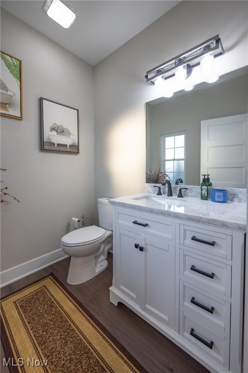 bathroom featuring vanity, hardwood / wood-style floors, and toilet