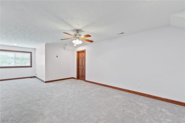 carpeted spare room featuring ceiling fan and a textured ceiling