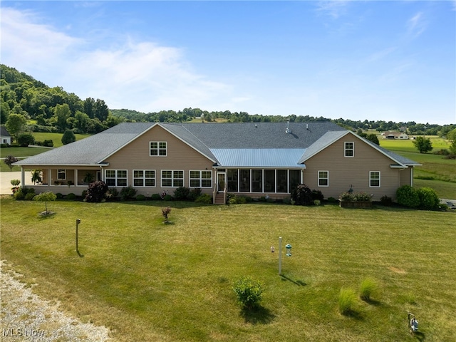 back of house featuring a lawn and a sunroom