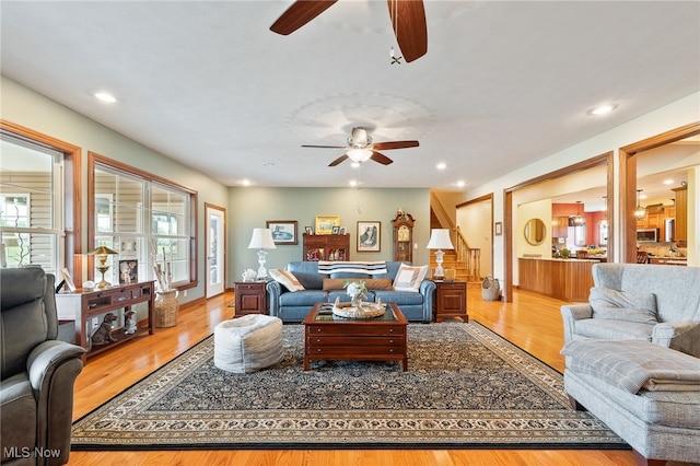 living room featuring light wood-type flooring and ceiling fan