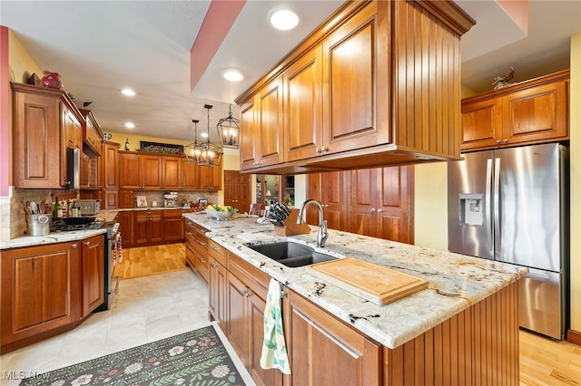 kitchen featuring decorative backsplash, sink, appliances with stainless steel finishes, and light stone countertops