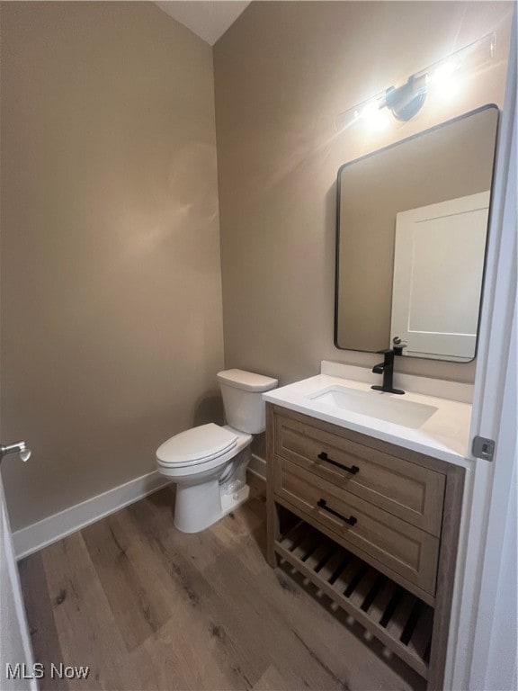 bathroom featuring vanity, toilet, and wood-type flooring