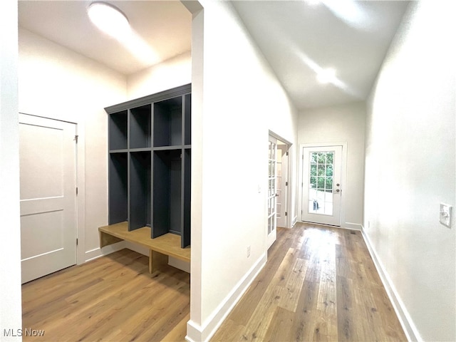 mudroom with vaulted ceiling and hardwood / wood-style flooring