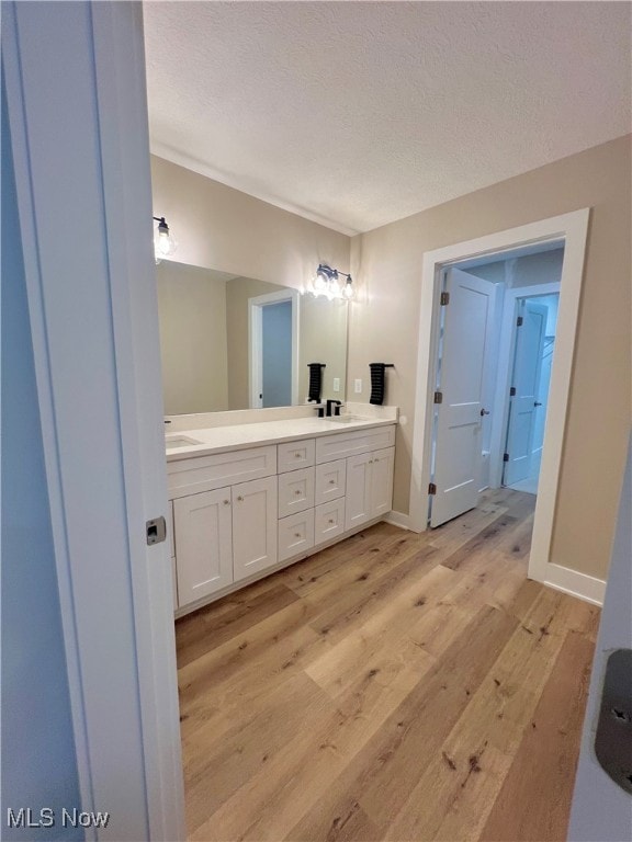 bathroom with vanity, hardwood / wood-style flooring, and a textured ceiling