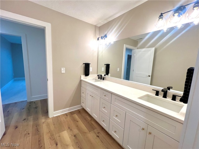 bathroom with vanity, hardwood / wood-style flooring, and a textured ceiling