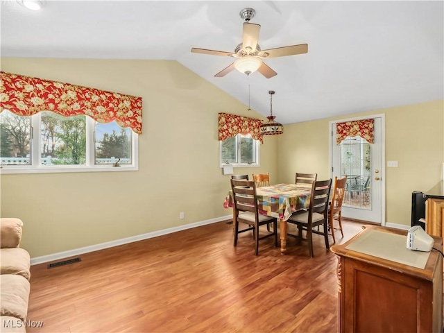 dining space with ceiling fan, hardwood / wood-style floors, and lofted ceiling