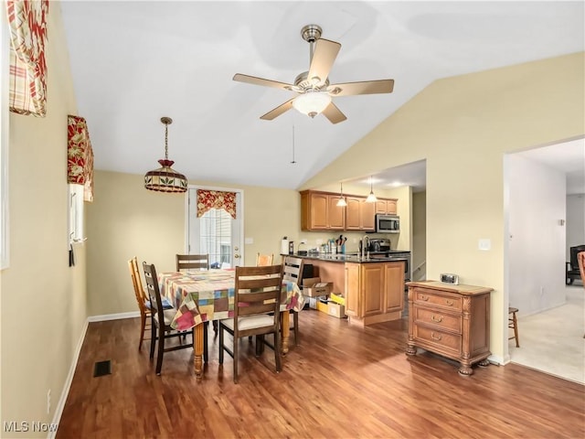 dining area featuring dark wood-type flooring, ceiling fan, lofted ceiling, and sink