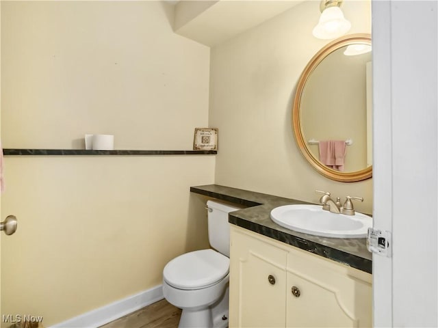 bathroom featuring vanity, hardwood / wood-style flooring, and toilet