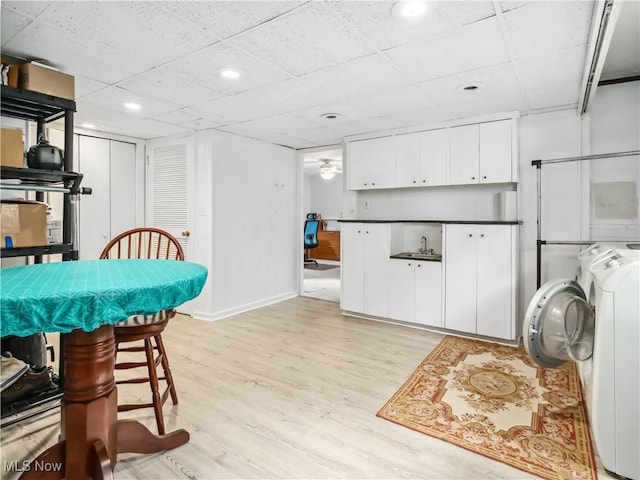 dining area featuring sink, light wood-type flooring, and washing machine and clothes dryer