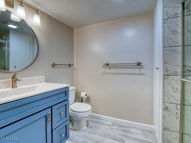 bathroom with walk in shower, hardwood / wood-style floors, a textured ceiling, toilet, and vanity