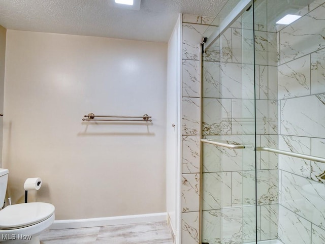 bathroom with a shower with shower door, a textured ceiling, and toilet