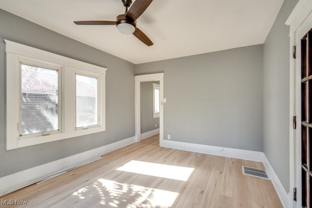 empty room with ceiling fan and light hardwood / wood-style floors