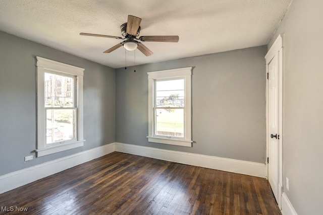 empty room featuring a textured ceiling, ceiling fan, and dark wood-type flooring