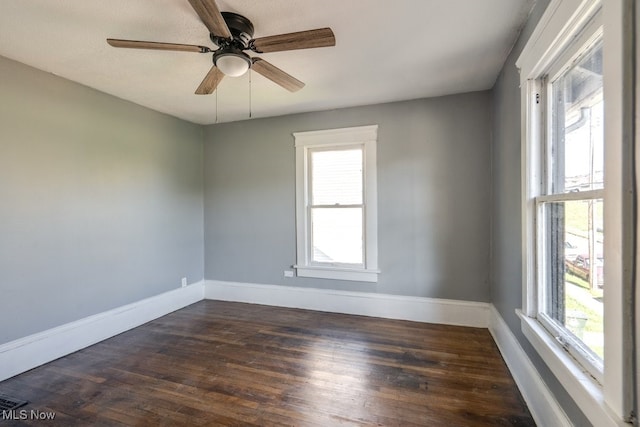 empty room with ceiling fan and dark hardwood / wood-style flooring