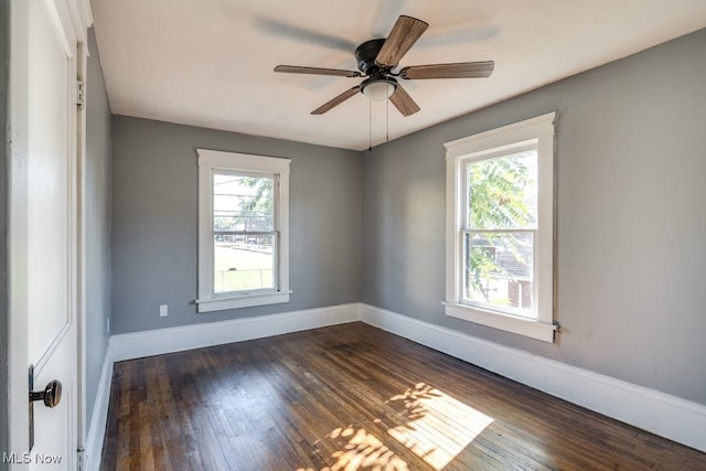 empty room with a wealth of natural light, ceiling fan, and dark hardwood / wood-style floors