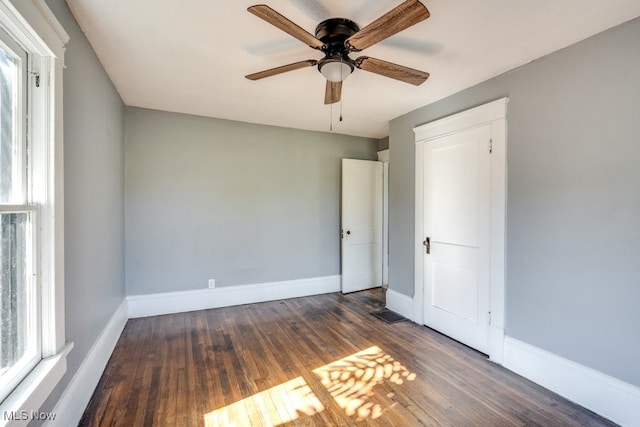 unfurnished room with ceiling fan and dark wood-type flooring