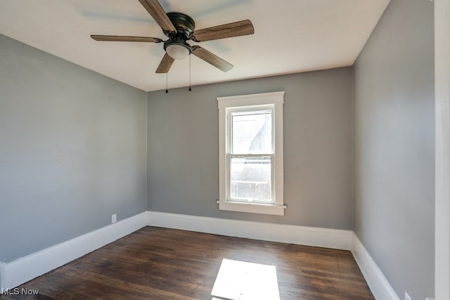 spare room featuring ceiling fan and dark wood-type flooring