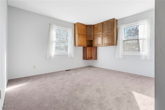 carpeted empty room with a wealth of natural light